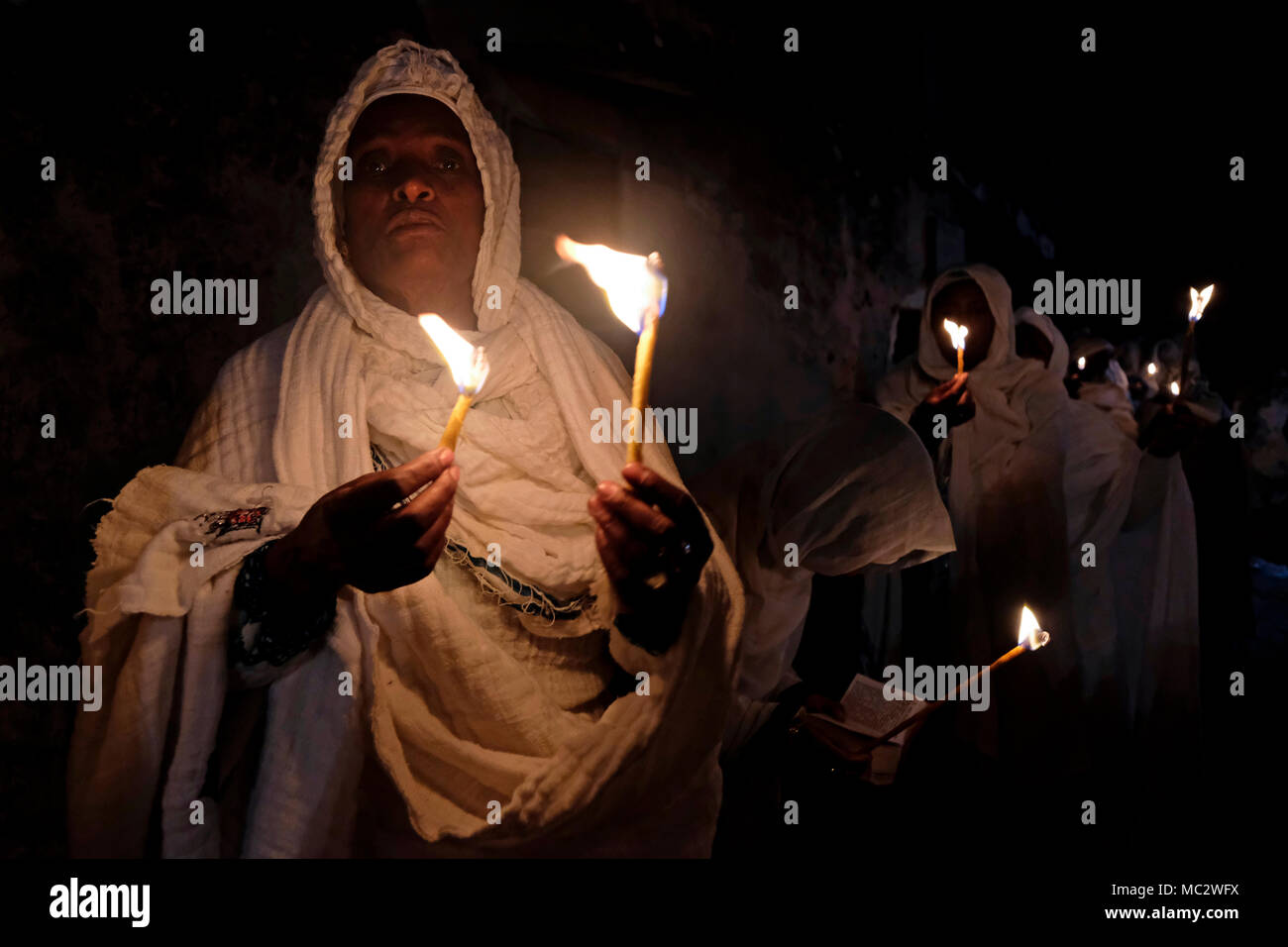 I cristiani ortodossi etiopi tengono candele durante la cerimonia del fuoco Santo al monastero di Deir El-Sultan situato sul tetto della Chiesa del Santo Sepolcro nella Città Vecchia Gerusalemme Est Israele. I cristiani etiopi commemorano gli eventi attorno alla crocifissione di Gesù Cristo, portando alla sua risurrezione nella Pasqua, che in lingua amarica, è chiamata Fasika, originata dalla parola greca Pascha. Foto Stock