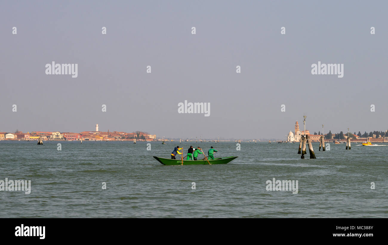 I rematori in laguna di Venezia con l'isola di Murano in background Foto Stock