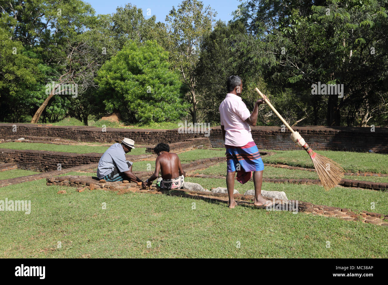 Sigiriya Nord provincia centrale dello Sri Lanka, uomini al lavoro su rovine nei dintorni di Sigiriya rock Foto Stock
