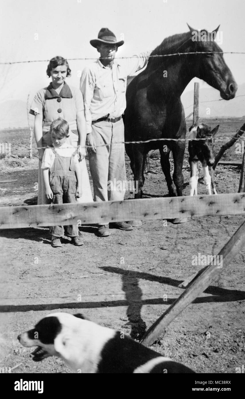 Un'azienda agricola di famiglia sulle grandi pianure degli Stati Uniti sta per un ritratto dietro qualche filo spinato, ca. 1935. Foto Stock