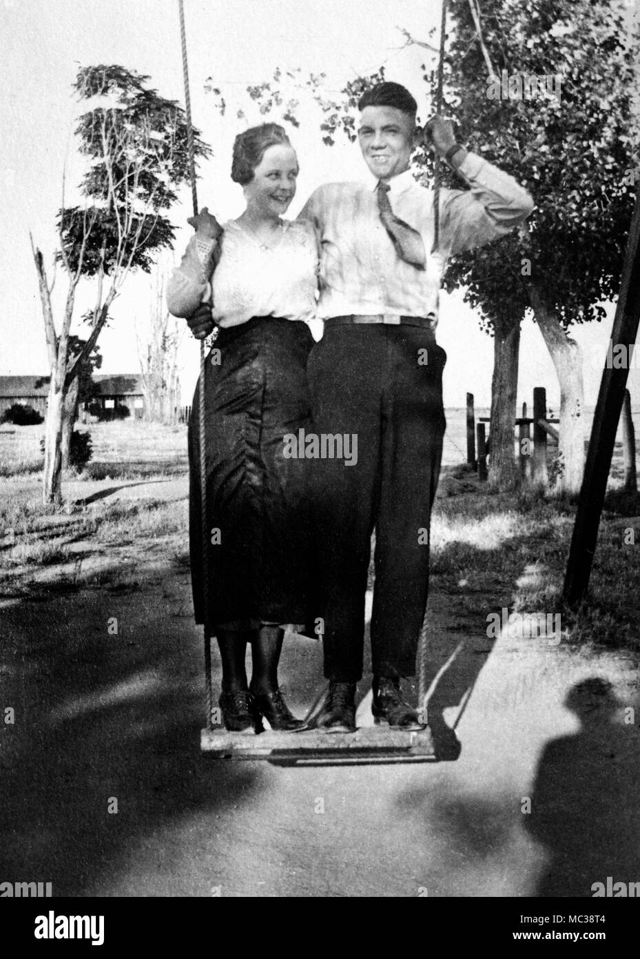 Una giovane coppia di stand su un insieme di oscillazione, ca. 1920. Foto Stock
