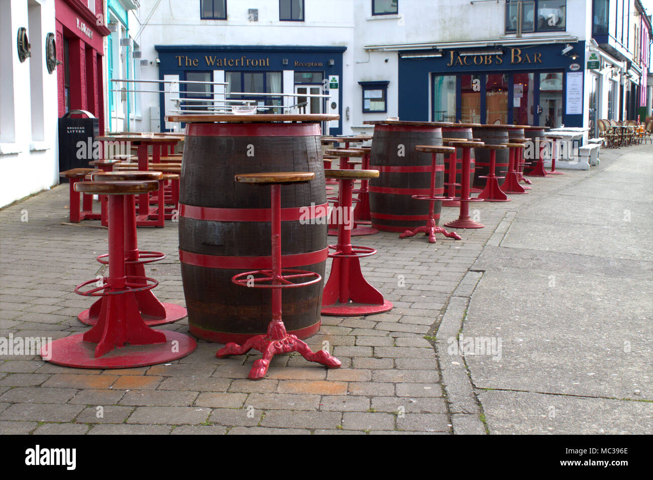 Tavoli e sedie composta di barili impostato in attesa per i clienti al di fuori del pub e ristoranti di Baltimora, West Cork, Irlanda. Foto Stock