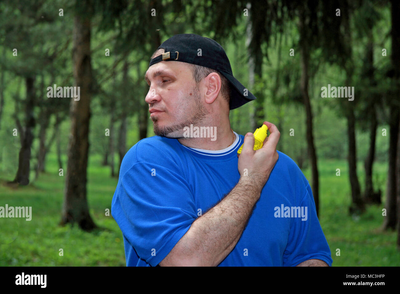 Un uomo nella foresta repellente spray sulla pelle per proteggere contro gli insetti. Foto Stock