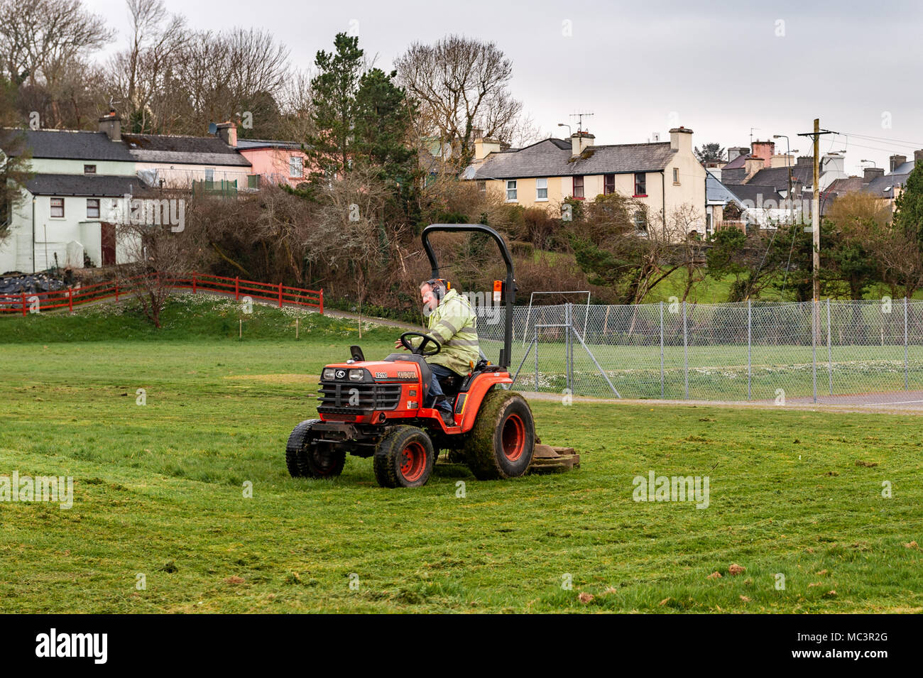 Del Consiglio di contea di Cork operaio taglio erba su un Kubota ride-sulla falciatrice in Ballydehob, County Cork, Irlanda con copia spazio. Foto Stock