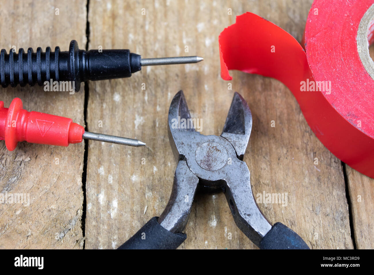 Accessori nel laboratorio di elettronica. Misuratore elettronico, saldatore e altri strumenti necessari per le riparazioni di dispositivi elettronici. Sfondo scuro. Foto Stock