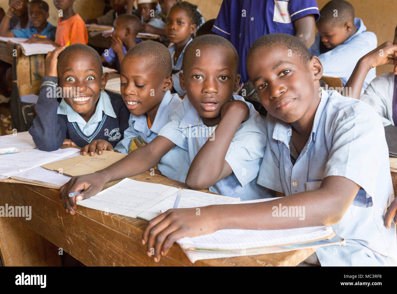 Uganda. Il 13 giugno 2017. Sorridente bambini ugandesi seduto alla scrivania in una classe nella scuola primaria in Kayanja. Foto Stock
