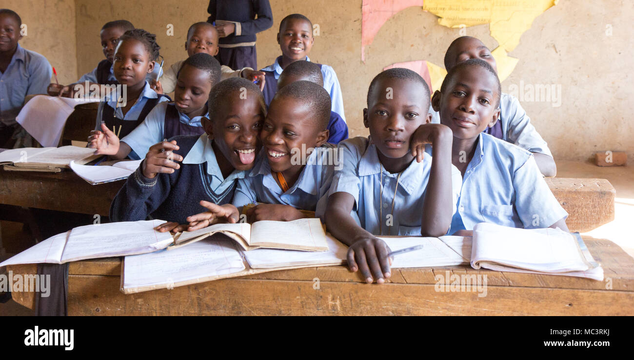 Uganda. Il 13 giugno 2017. Sorridente bambini ugandesi seduto alla scrivania in una classe nella scuola primaria in Kayanja. Foto Stock