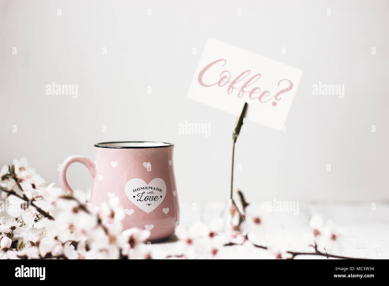 Rosa tazza da caffè, fiori di colore bianco e "caffè?' nota, su sfondo bianco Foto Stock
