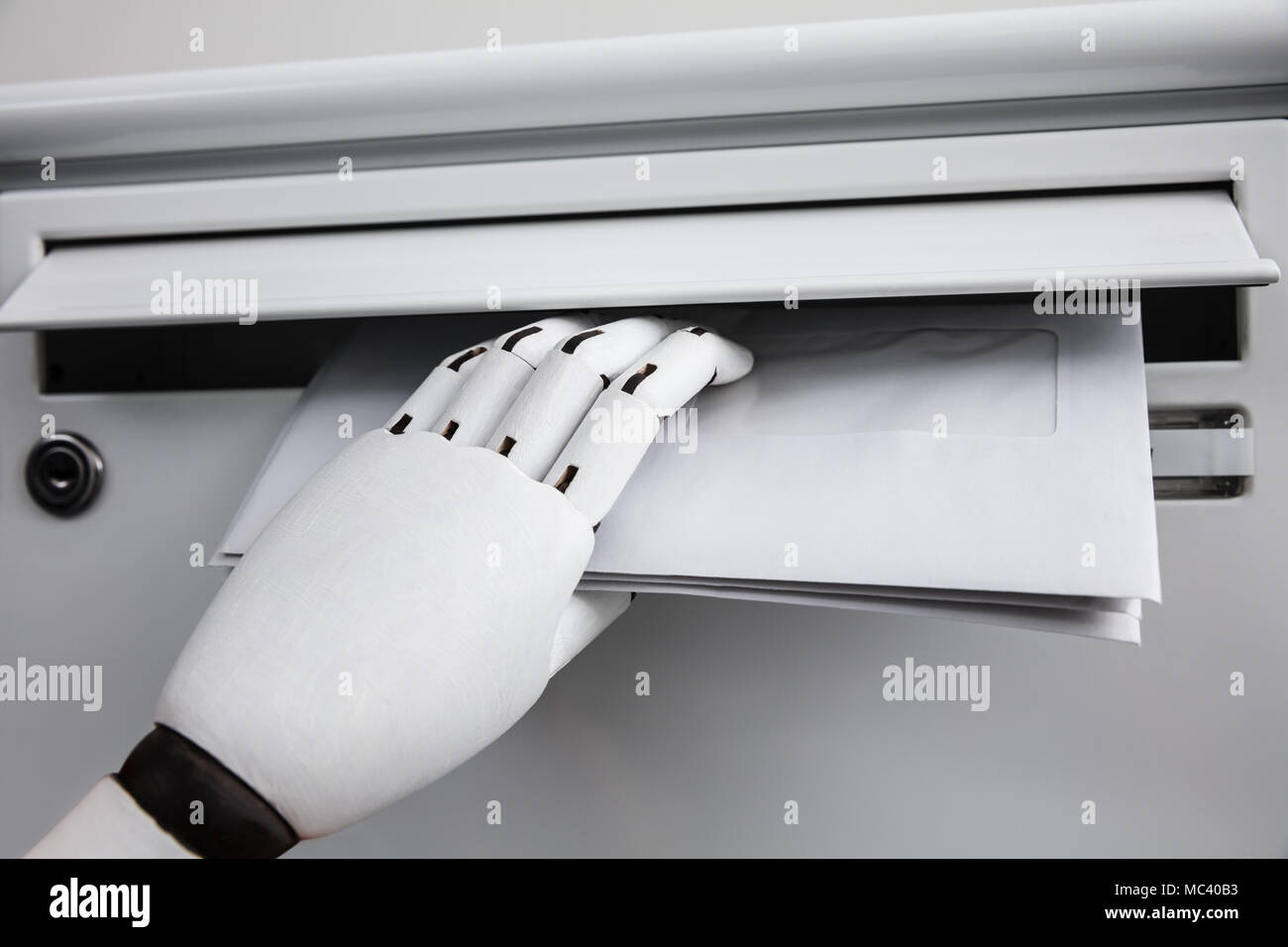Close-up di una mano robotica di inserimento busta In mailbox Foto Stock Close-up di una mano robotica di inserimento busta In mailbox Foto Stock
