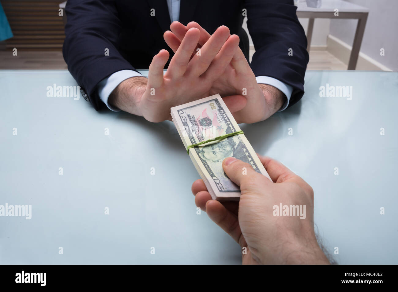 Close-up di un imprenditore il canto rifiutare corrompere offerto dai suoi partner Foto Stock