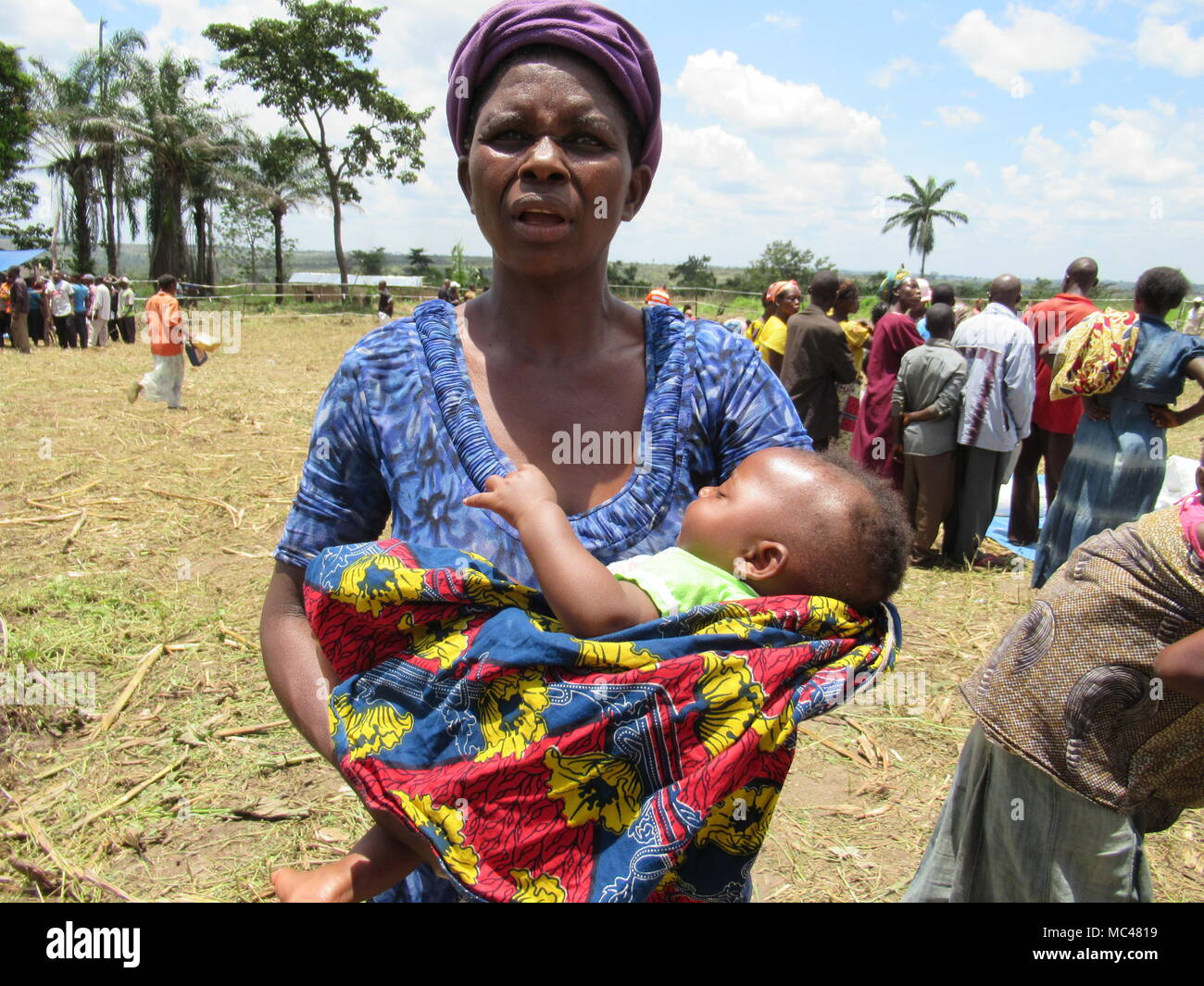 13 marzo 2018, Congo, Kananga: Un bambino dorme tra le braccia della madre come lei attende per la registrazione e l'esame sanitario del suo bambino per misurare il grado di malnutrizione in un programma alimentare mondiale sito di distribuzione in Congo·s Kasai travagliata regione. L'ONU afferma che 3 milioni di persone nel Kasai si trovano di fronte a una grave penuria di cibo a causa di conflitto. Foto: Kate Bartlett/dpa Foto Stock