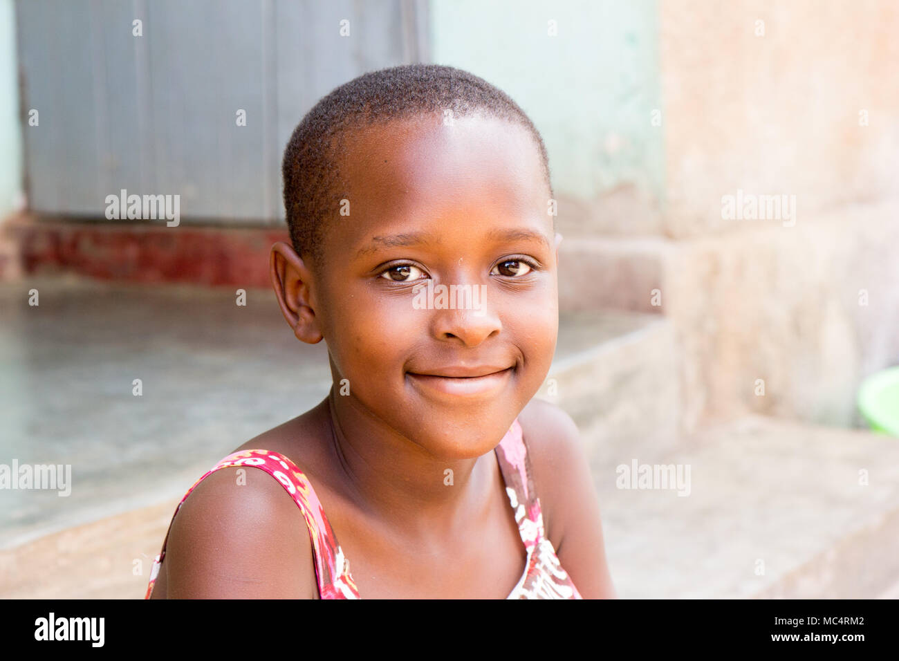 Lugazi, Uganda. 14 maggio 2017. Un ritratto di una bella ragazza ugandese seduta sulle scale di fronte a una casa. Foto Stock