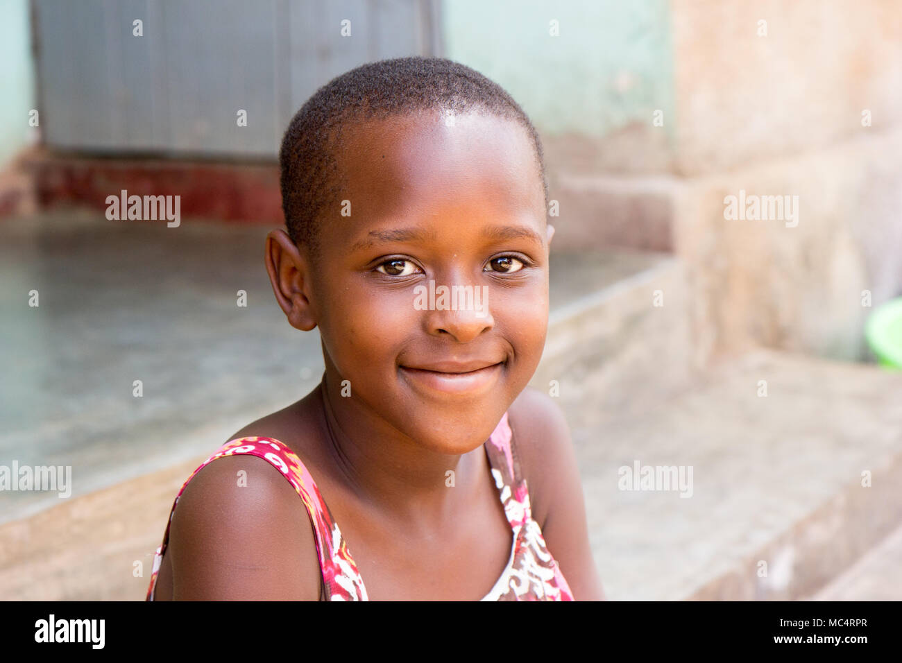 Lugazi, Uganda. 14 maggio 2017. Un ritratto di una bella ragazza ugandese seduta sulle scale di fronte a una casa. Foto Stock