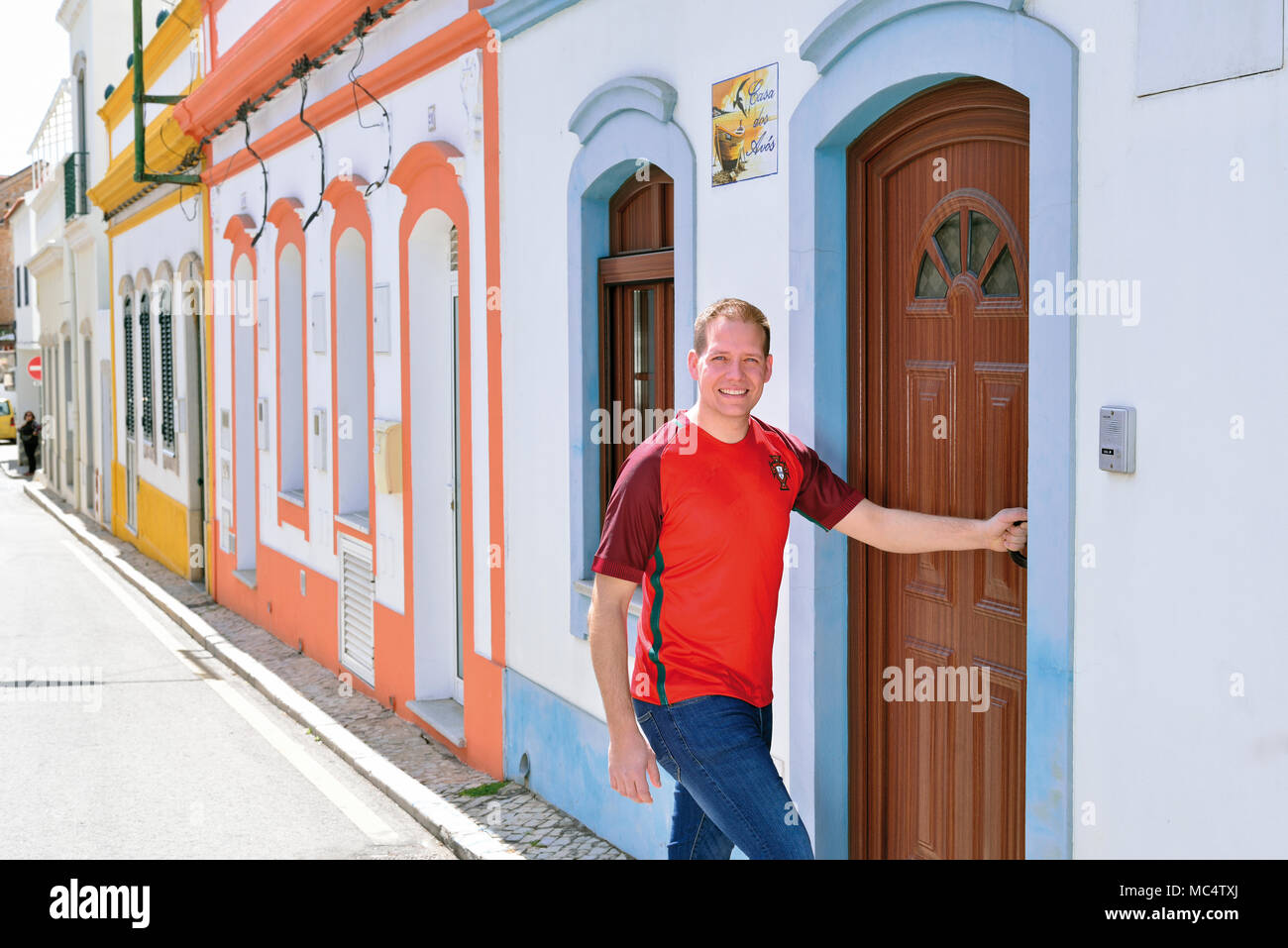 Il giovane portoghese con National Soccer team shirt entrando in una casa tipica a Tavira Foto Stock