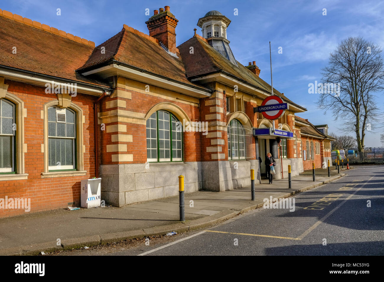 Barkingside, Ilford, Essex, Regno Unito - 6 Aprile 2018: vista esterna di Barkingside stazione della metropolitana con un passeggero in partenza dall'ingresso. Foto Stock