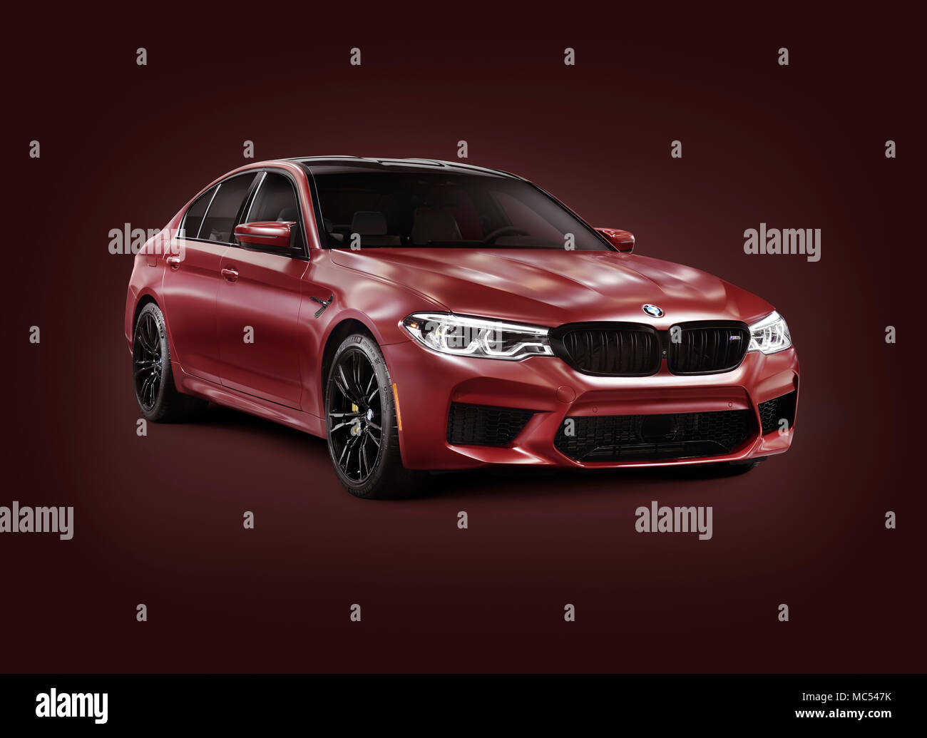 La sesta generazione di BMW M5, 2018 performance car, luxury sport sedan, serie 5 in rosso scuro di colore opaco. Isolato con un tracciato di ritaglio su Borgogna backgro Foto Stock
