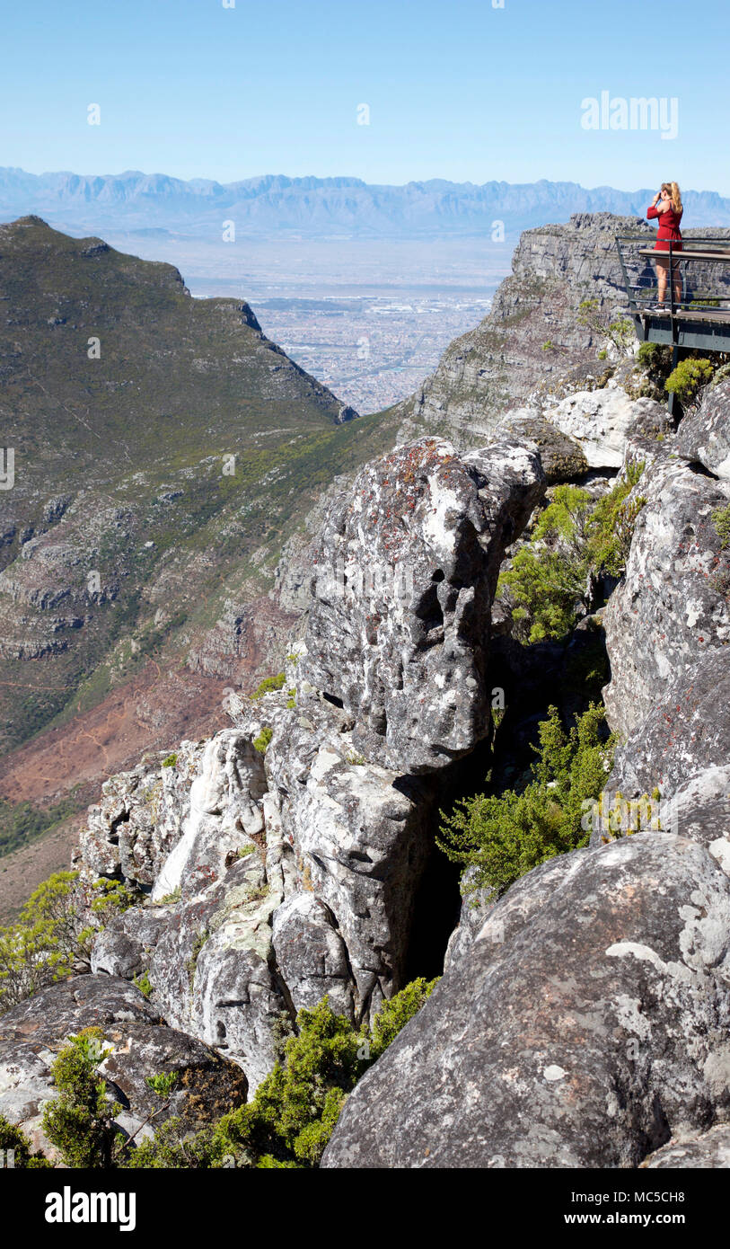 Donna photograping Vista della Montagna Nera da Table Mountain summit, Cape Town, Sud Africa Foto Stock