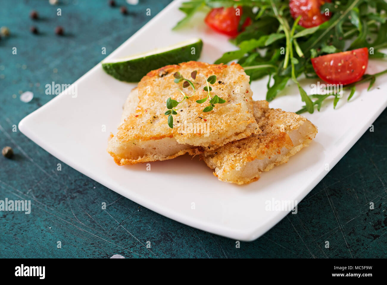 Bianco fritto i filetti di pesce e insalata di pomodoro con foglie di rucola. Foto Stock