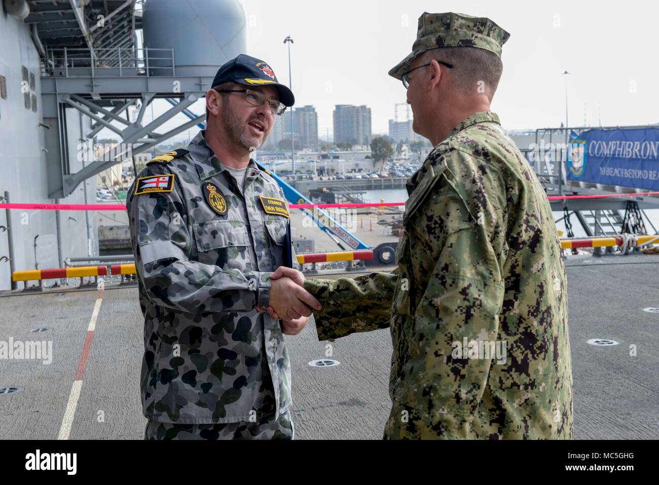 180405-N-PX867-371 SAN DIEGO (5 aprile 2018) Capt. Benjamin Allbritton, comandante di assalto anfibio nave USS Boxer (LHD 4), scuote le mani con posteriore Adm. Ivan Ingham, Commodore Warfare, Royal Australian Navy, sul quarterdeck durante un tour della nave. Boxer è pierside nella sua preparazione homeport per Commander, Navale di forze di superficie alle prove in mare. (U.S. Foto di Marina di Massa lo specialista di comunicazione di terza classe Justin Whitley/rilasciato) Foto Stock