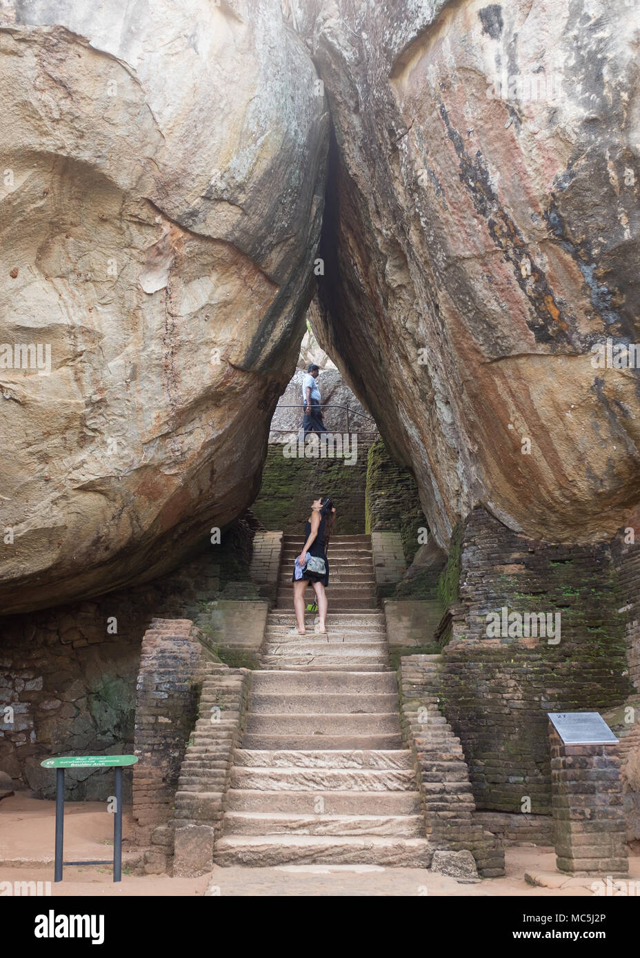 Donna in piedi al boulder ingresso di Sigiriya rock fortezza, provincia centrale, Sri Lanka, in Asia. Foto Stock