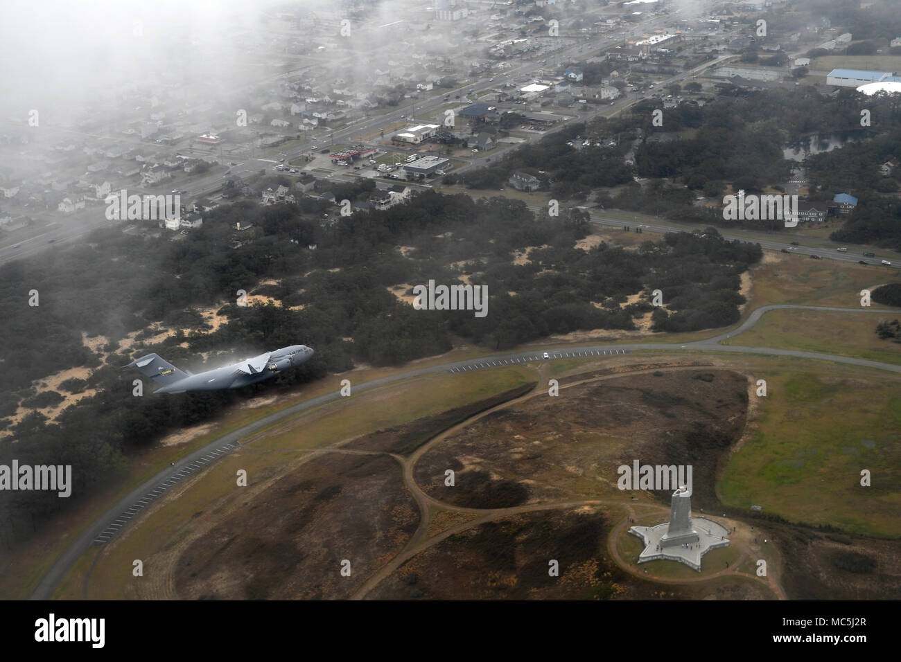 Il C-17 Globemaster III è un aereo da trasporto strategico prodotto dalla Boeing per la United States Air Force. Il 7 aprile 2018, un aereo assegnato al 145th Airlift Wing volò sopra il Wright Brothers National Memorial a Kill Devil Hills, Carolina del Nord, in rotta verso l'aeroporto internazionale Charlotte Douglas per una cerimonia di accettazione. L'immagine d'archivio documenta l'aereo in volo sopra il punto di riferimento costiero. Foto Stock