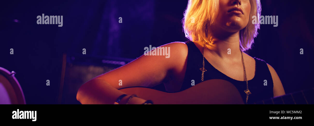 Femmina a suonare la chitarra in discoteca Foto Stock