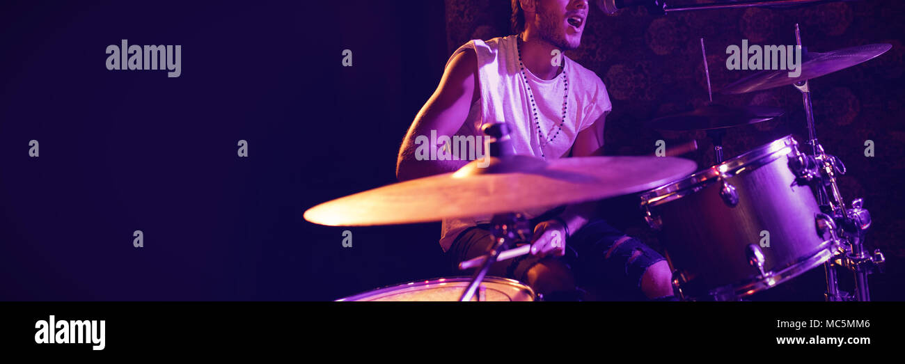 Il cantante suonando la batteria mentre si esegue in discoteca Foto Stock