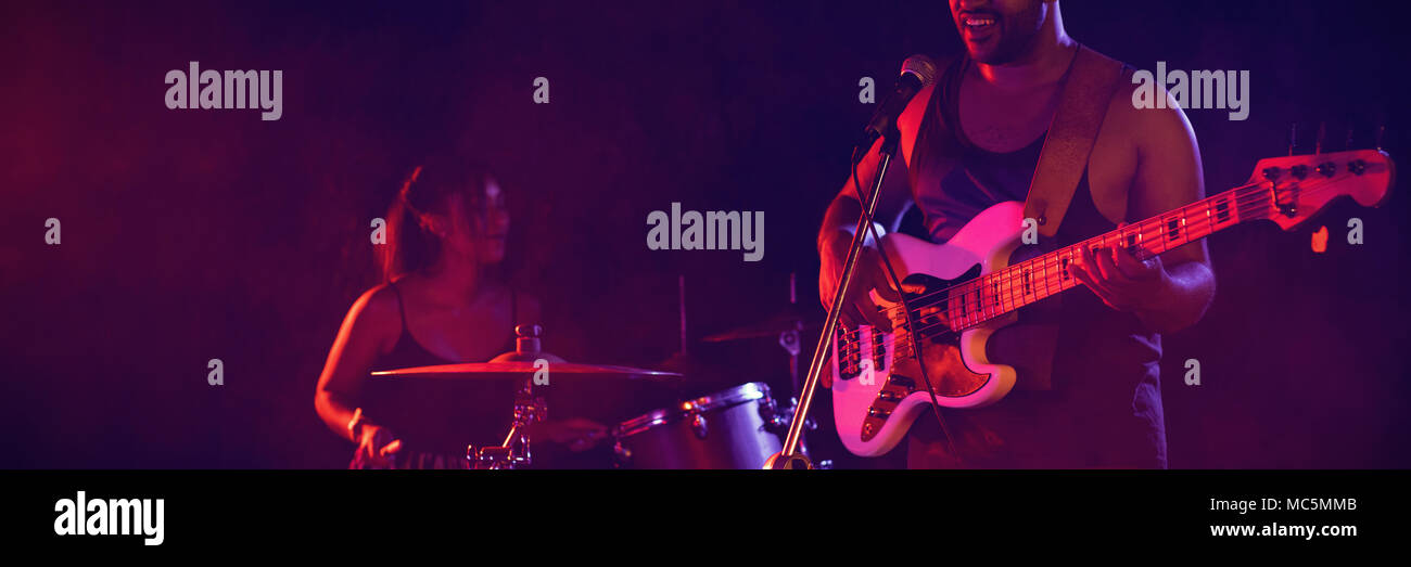 Uomo a suonare la chitarra con il batterista in discoteca Foto Stock