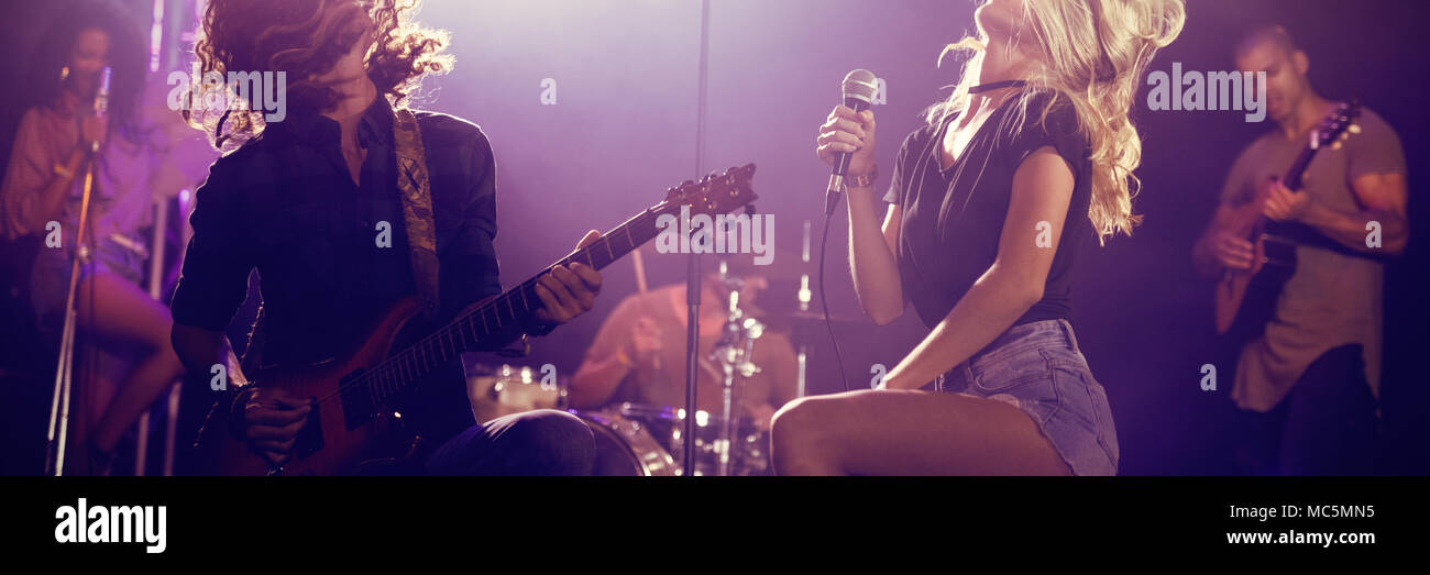 Il cantante e chitarrista maschio con capelli tousled eseguendo in discoteca Foto Stock