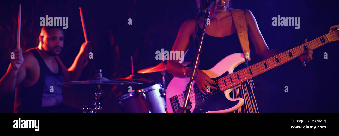 La donna a suonare la chitarra da batterista in concerto Foto Stock