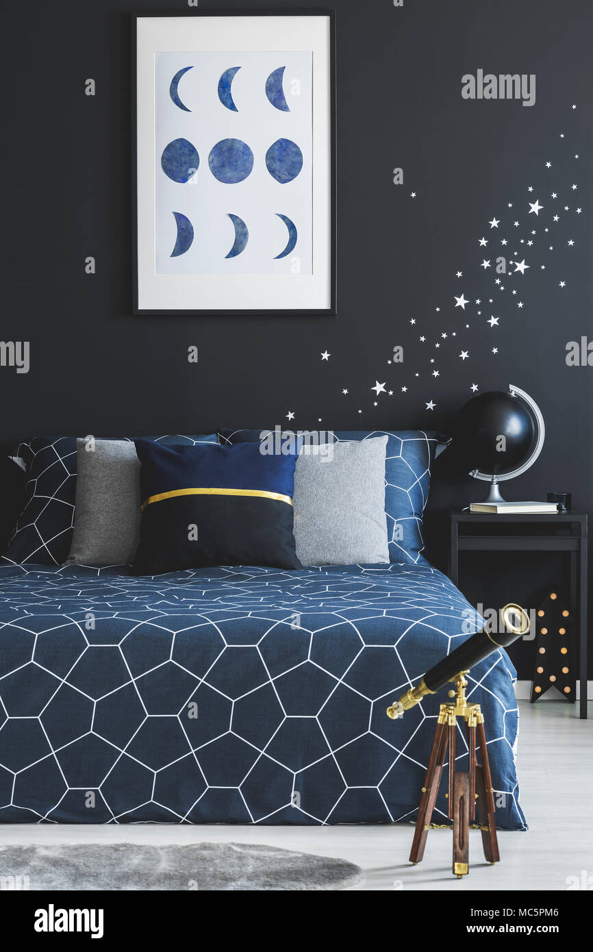 Telescopio accanto a navy blue bed contro la parete scura con stelle  adesivi e poster in camera da letto interno Foto stock - Alamy