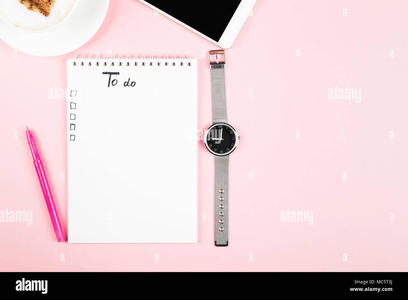 Il concetto di pianificazione mattino, lista Da fare - cappuccino, notebook, penna, telefono, guarda su sfondo rosa. Vista superiore, spazio di copia Foto Stock