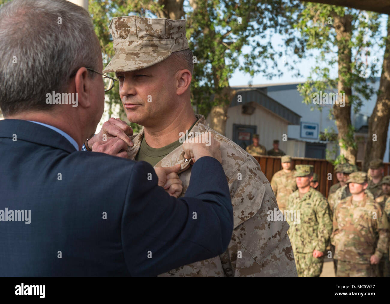 Stati Uniti Ambasciatore a Gibuti Larry André perni sulla seconda stella a U.S. Marine Corps Brig. Gen. David Furness, Comandante generale della Combined Joint Task Force - Corno d Africa, come egli è promosso al rango di maggiore generale presso il Camp Lemonnier, Gibuti, Marzo 24, 2018. Come il comandante, Furness supervisiona il comando gli sforzi nella lotta contro l'estremismo violento in Africa orientale, la promozione della cooperazione regionale la cooperazione in materia di sicurezza, rafforzamento della nazione partner la capacità di difesa e la costruzione e il mantenimento degli Stati Uniti accesso strategica nella regione. Foto Stock
