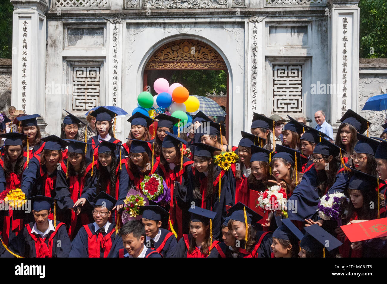 Gli studenti che festeggiano il loro diploma presso l'ingresso al Tempio della Letteratura, Hanoi, Viet Nam Foto Stock