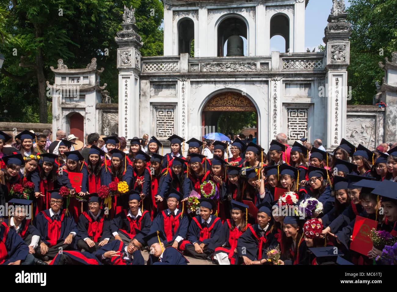 I laureati celebrando nella parte anteriore del furgone Mieu Gate (Văn Miếu Môn), l'ingresso al Tempio della Letteratura, Hanoi, Viet Nam Foto Stock