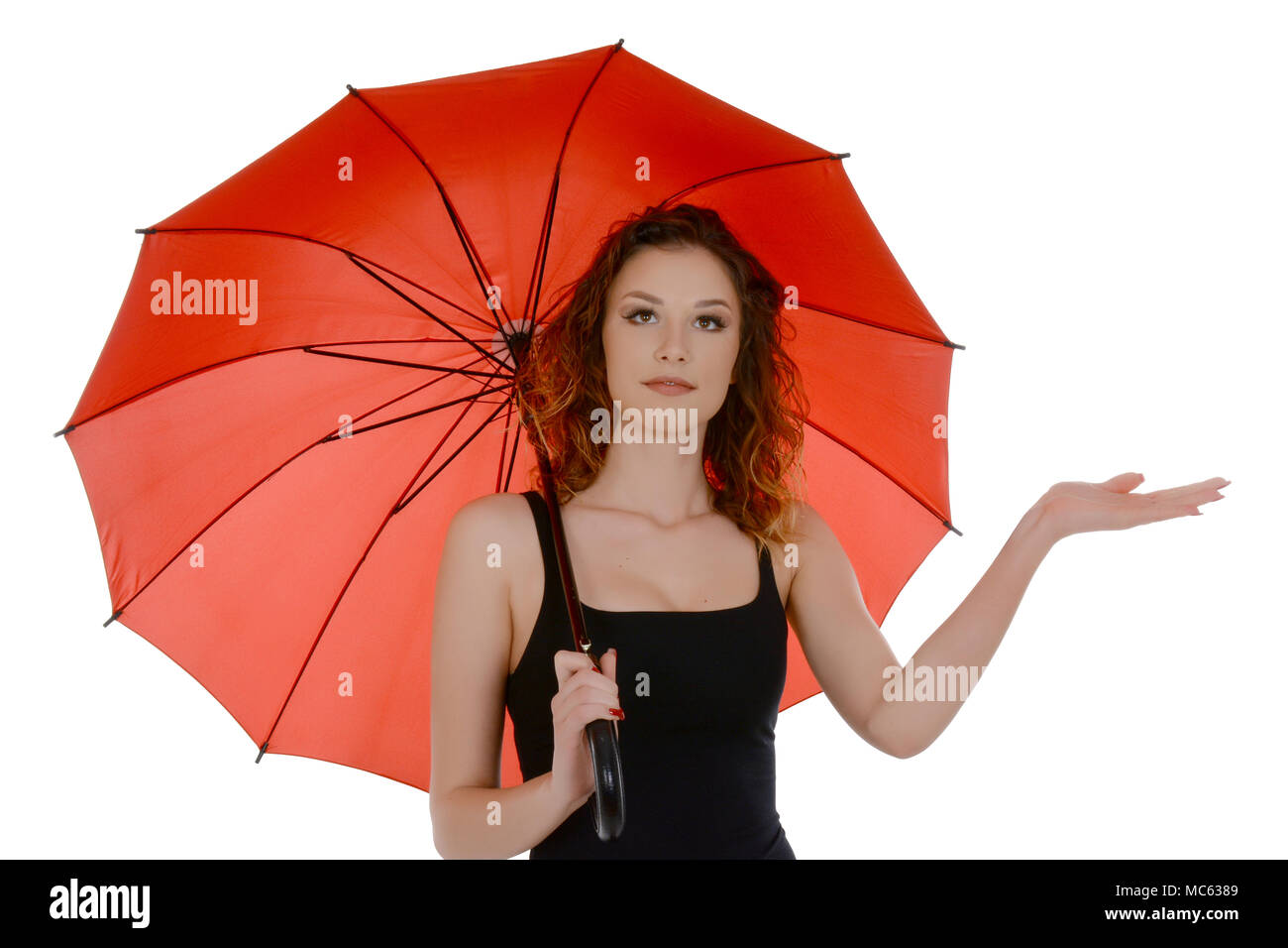 Giovane donna con ombrello rosso controllare se piove, isolati su sfondo bianco Foto Stock