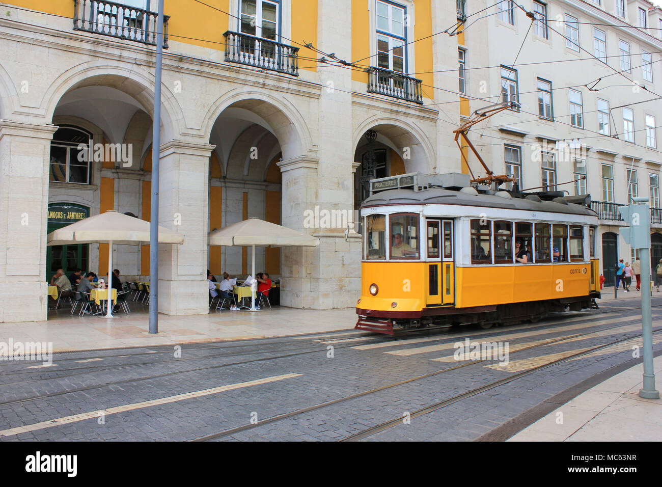 Lisbona, Portogallo - Giugno, 2017: Lisbona tram giallo sul modo di Commerce Square nella città vecchia. Famoso vintage viaggi turistici attrazione sul giorno di estate Foto Stock