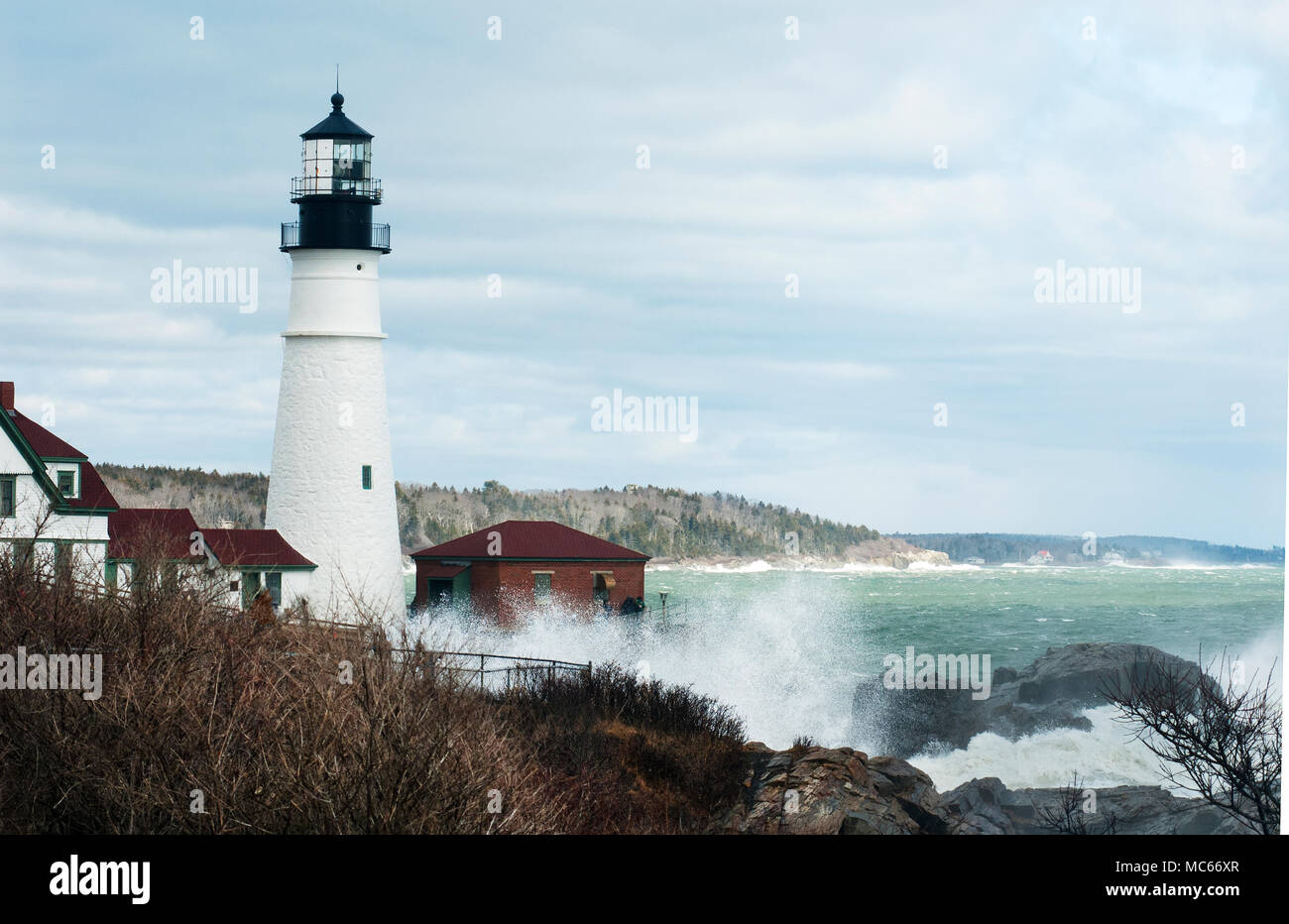 High surf da rare astronomicamente alte maree break su roccia dal faro di Portland nel Maine. Foto Stock