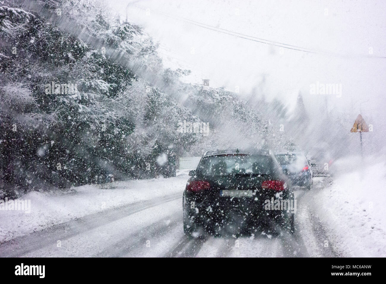 Guida auto durante l'inverno la neve presa attraverso un parabrezza ricoperta con blured fiocchi di neve. Foto Stock