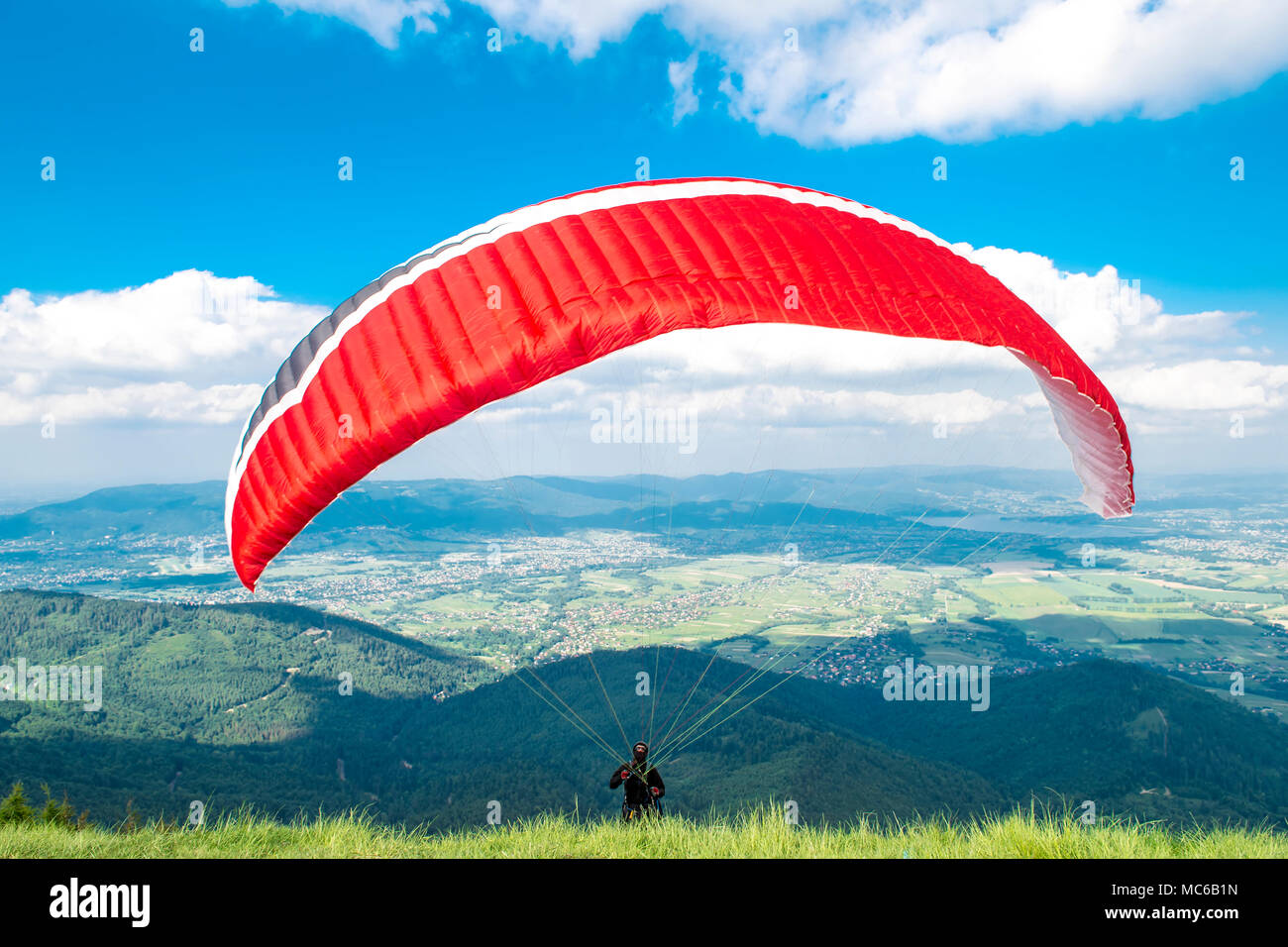 Parapendio in fase di avviamento di fronte alle montagne. Foto Stock