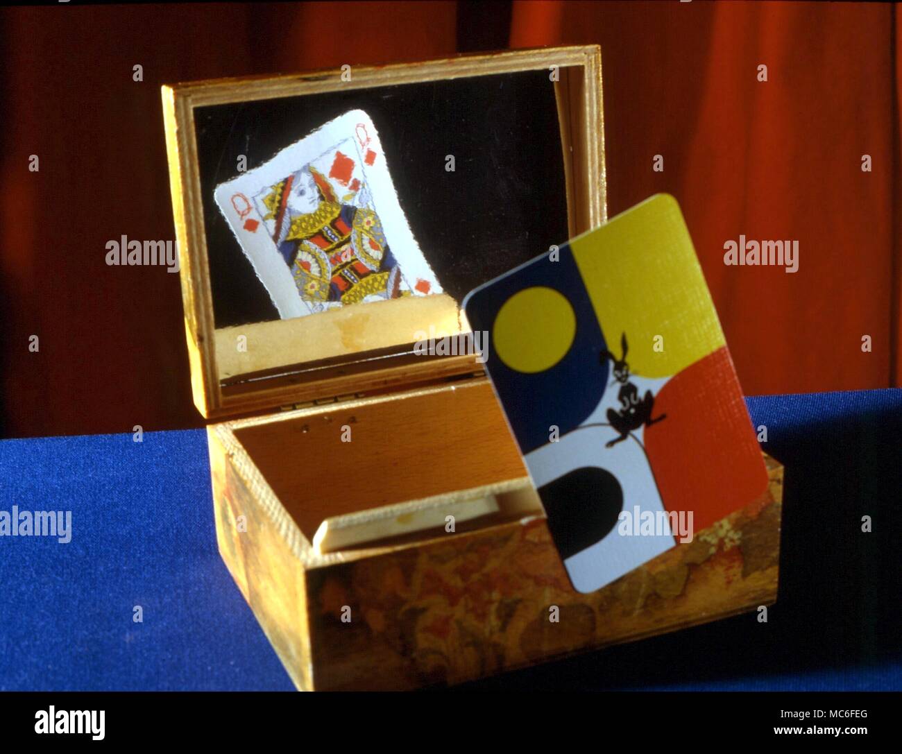 STAGE MAGIC - il mago è in grado di nome ogni card egli mostra al pubblico. Questo trucco funziona perché ha uno specchio nascosta all'interno della scatola e può identificare le carte come egli li solleva Foto Stock