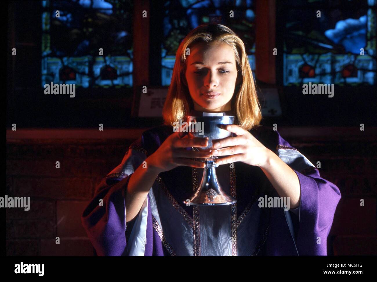 CHRISTIAN - Donna sacerdote. Sacerdotessa all altare con il Santo Calice Foto Stock