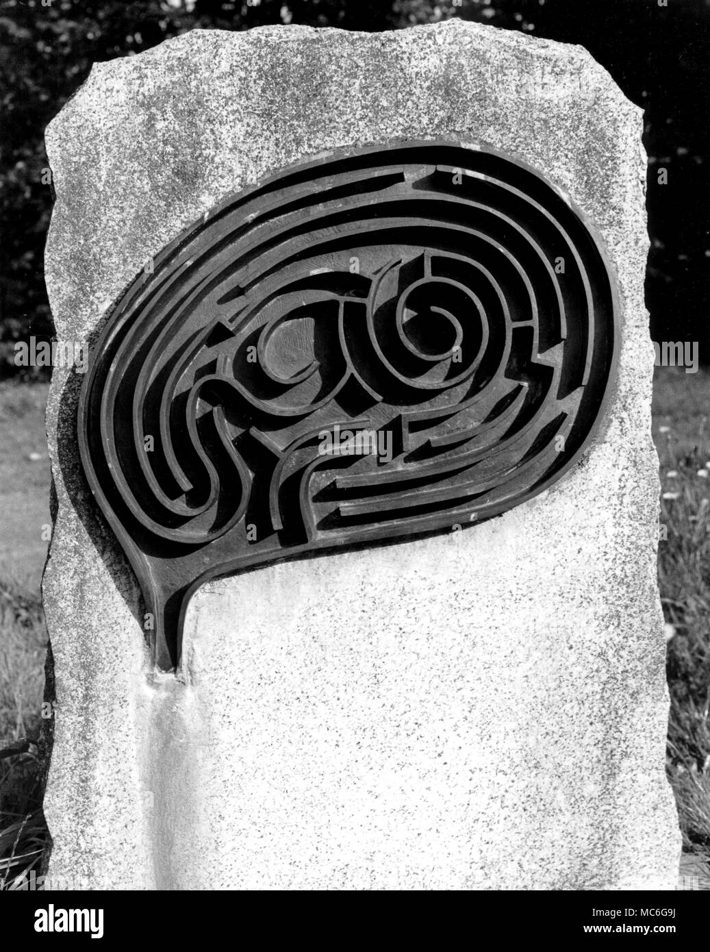 Labirinti - HADSTOCK fotografia del labirinto sulla lastra tombale dell'artista, Michael Aryton (morto nel 1975), nella sepoltura g turni di St Botolph's Church, Hadstock. Questo labirinto, con pareti rialzate, è costruita in rame. Esso design ricorda Aryton di interesse per la storia di Daedalus, l'artigiano ateniese che si suppone di avere progettato il labirinto di Creta, in cui il terribile uomo-bull (il minotauro) era stato imprigionato. Daedalus è famosa per le ali ha costruito da piume e cera, per consentire a lui e suo figlio Icarus per sfuggire l'isola di Creta. Poiché il Aryton maze è design Foto Stock