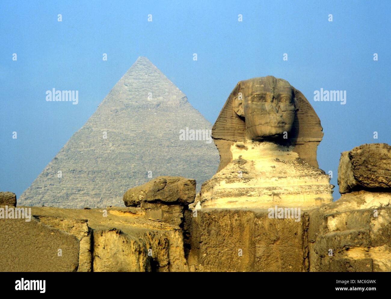 Mitologia egiziana - La Sfinge a Giza, con uno dei tre piramidi in background Foto Stock