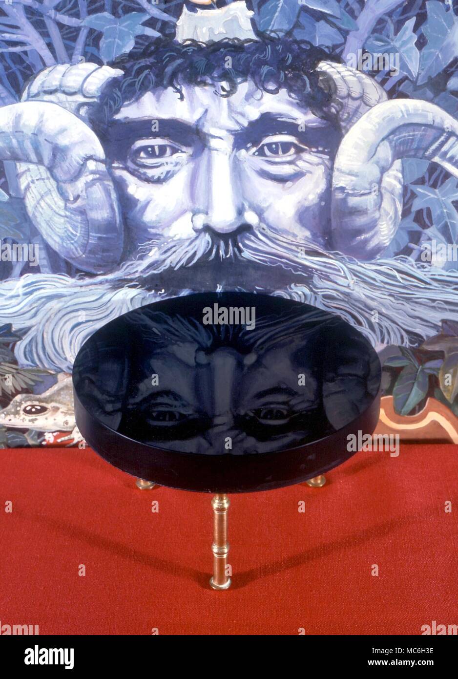 SCRYING - un vetro scrying, talvolta chiamato uno specolo, di fronte a un dipinto occulto di una testa mitologici. In questi jet-black superfici lucidate, veggenti sono in grado di vedere le immagini, spesso utile in divinazione Foto Stock
