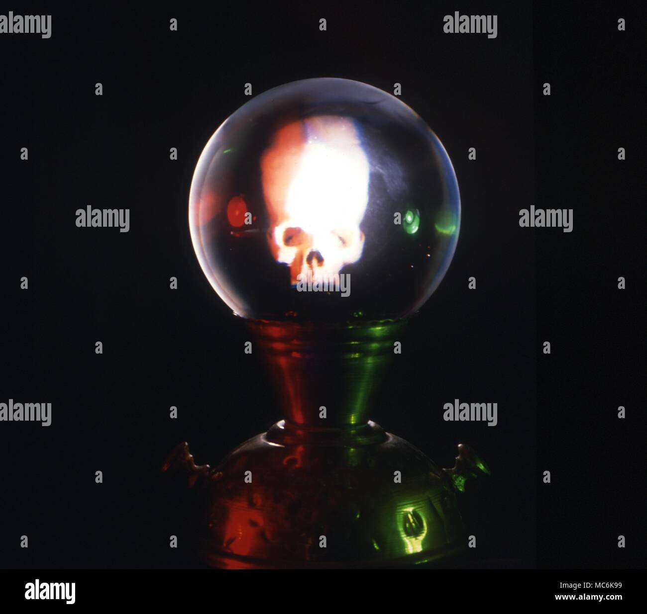 Fissando lo sguardo di cristallo. Cristallo con cranio riflessa in vetro contro uno sfondo scuro Foto Stock