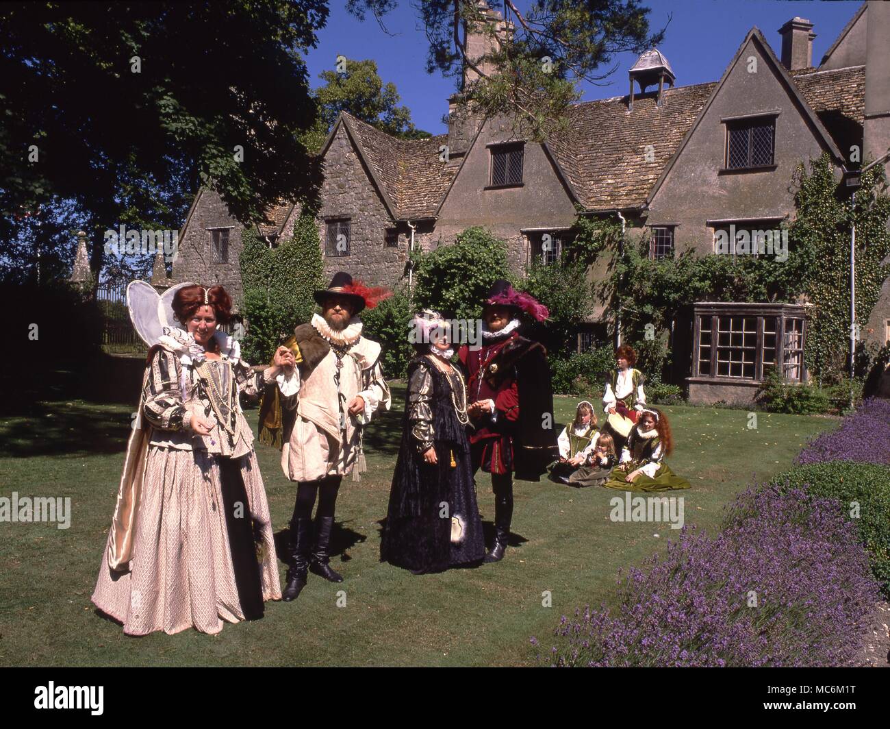 Parata di costumi storici nel giardino delle erbe di Avebury Manor. Wiltshire Foto Stock