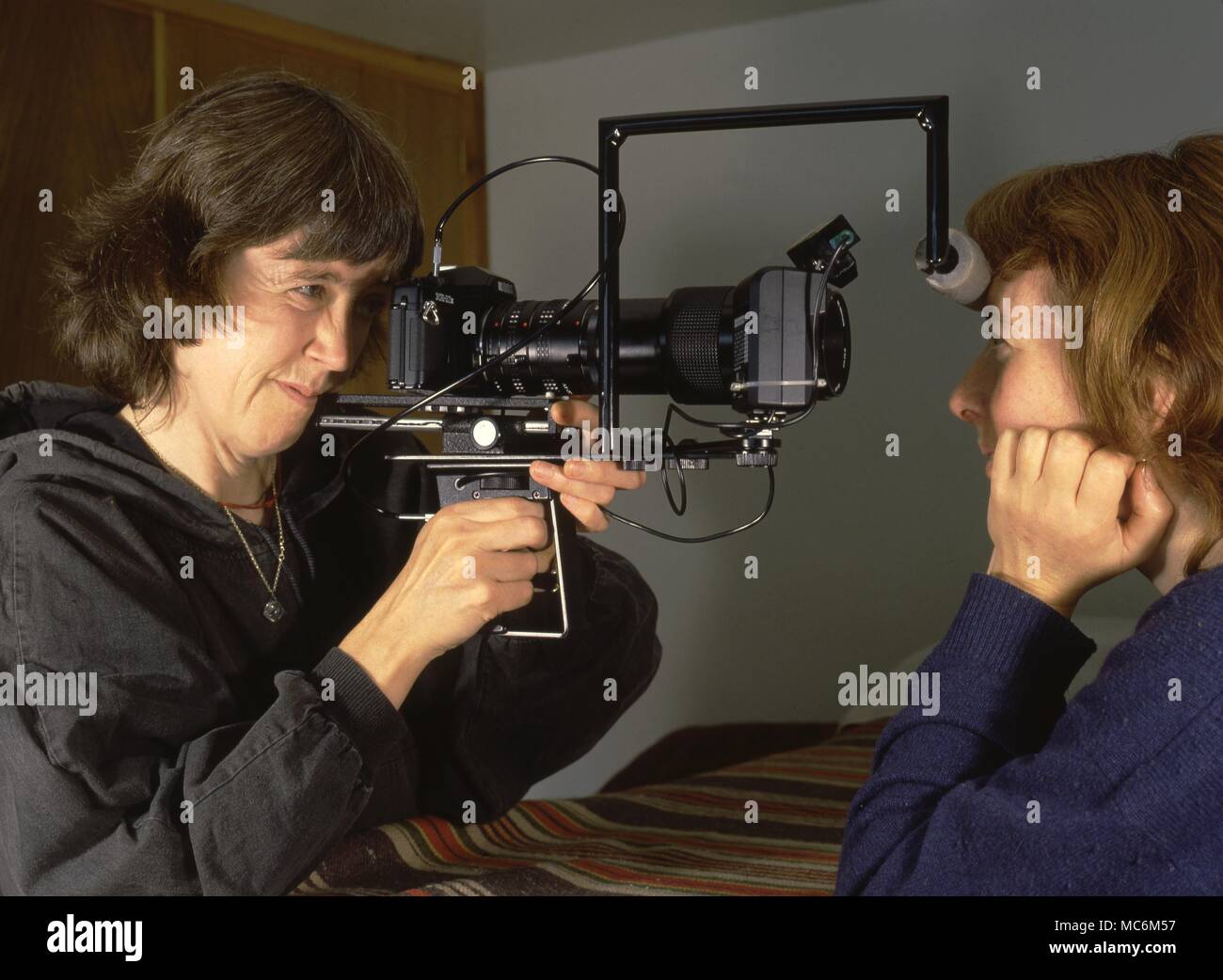 Iridology. Il iridologist ed erboristeria, Barbara Penny, scattare fotografie dell'occhio di un allievo come un aiuto alla diagnosi iridological. Foto Stock