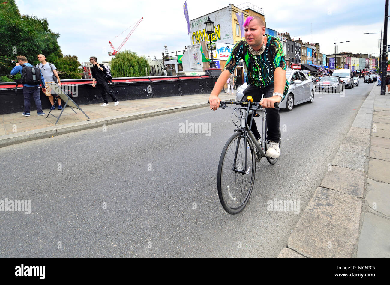 Londra, Inghilterra, Regno Unito. Camden - uomo con capelli rosa su una bici Foto Stock