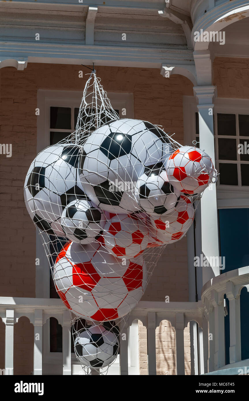 Spugna di palloni da calcio in vendita appeso al di fuori di un negozio in  estate Foto stock - Alamy